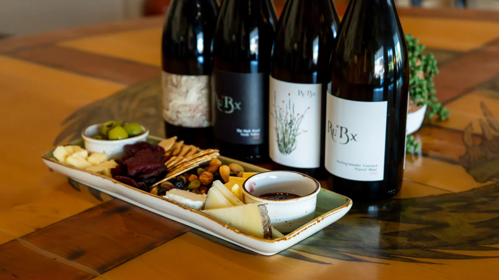 Ru°Bx wine bottles with a charcuterie board