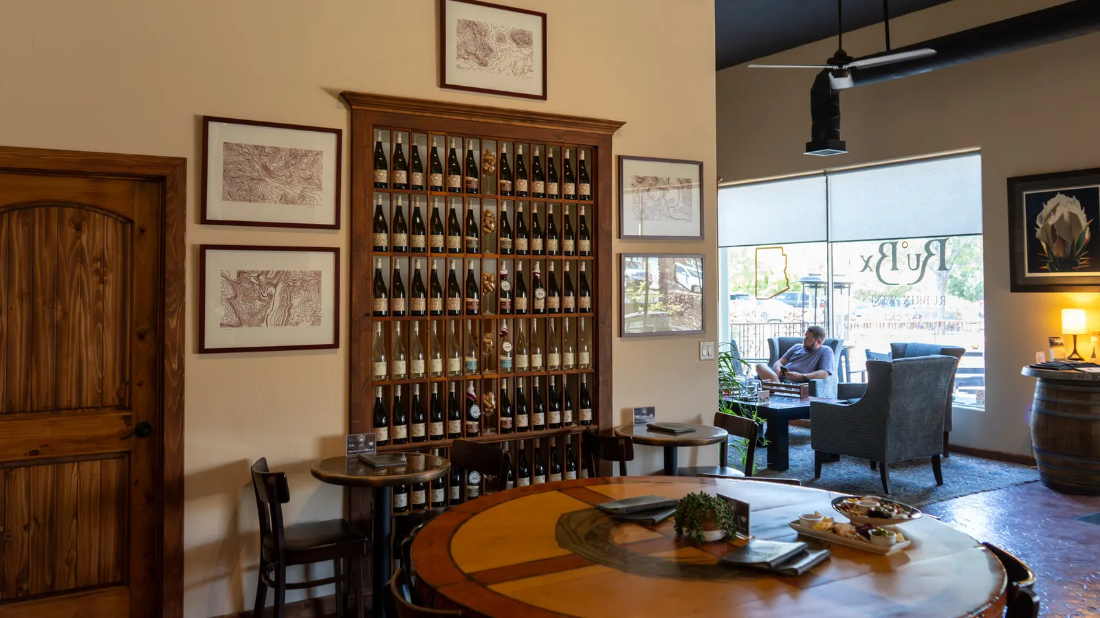 Ru°Bx Winery tasting room with a wall of wine bottles and a round wooden table
